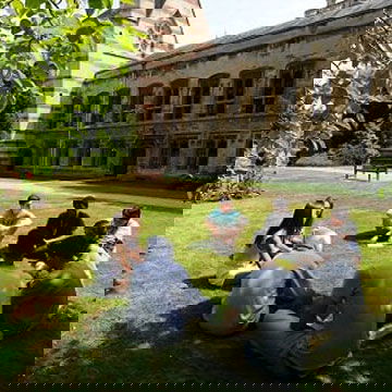 students sat on the grass in a circle, at a college of Oxford University
