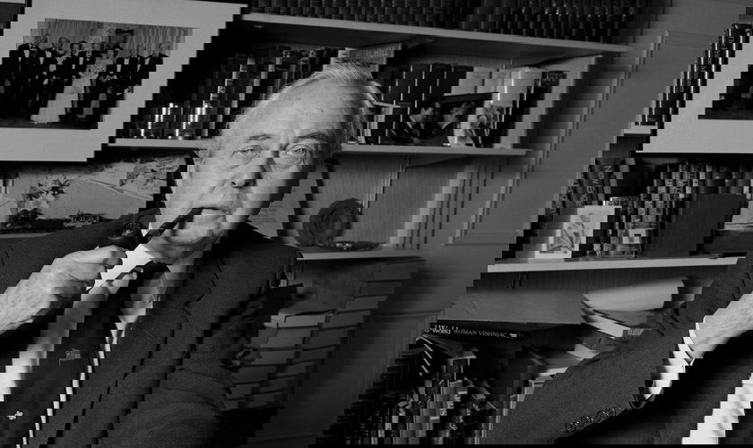 Image shows a black and white photo of Harold Wilson smoking a pipe