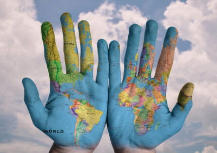 Global Issues summer school - World map painted across palms of the hands